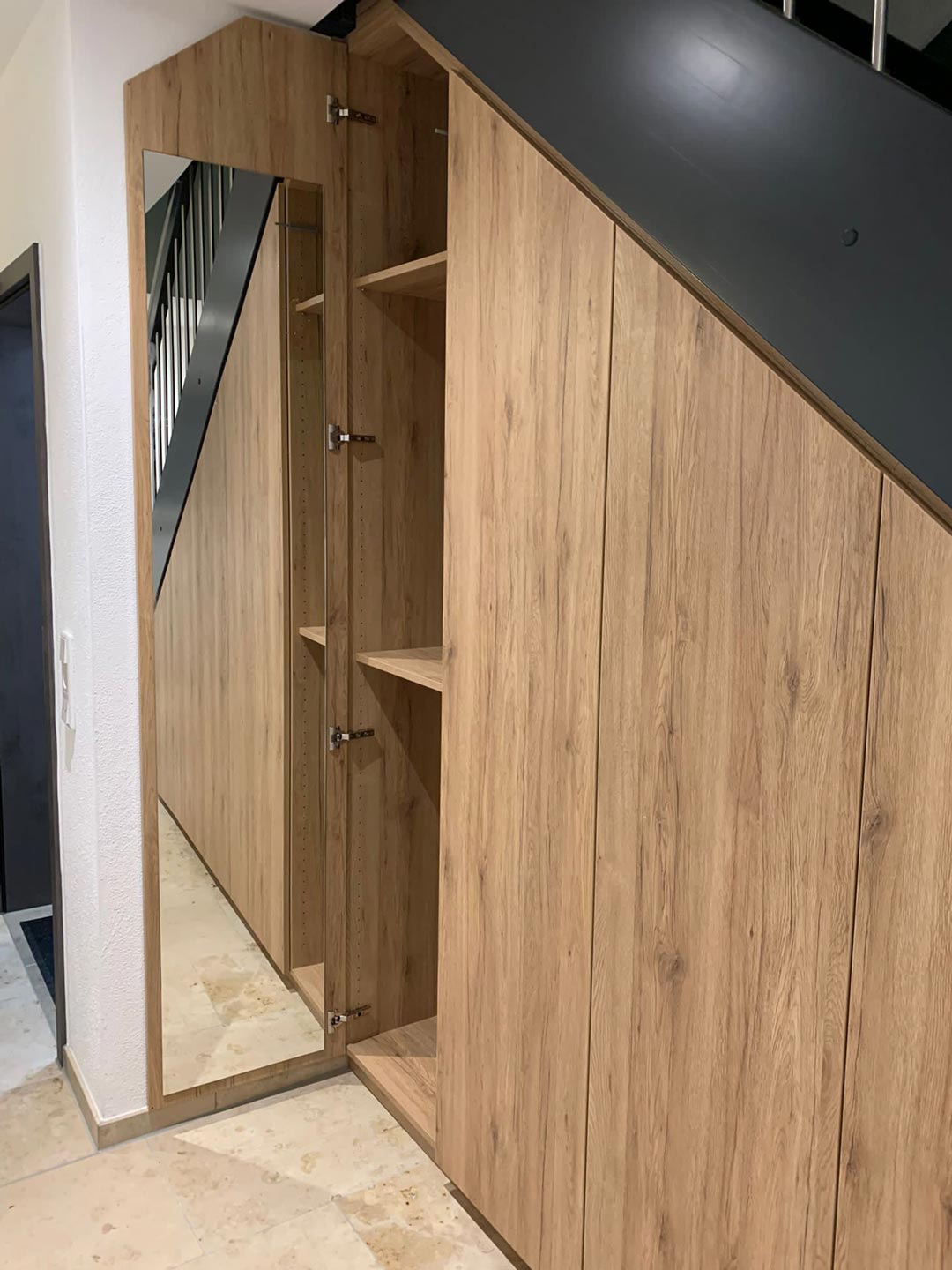 Der maßgefertigte Garderobenschrank in Eiche San Remo, kontrastiert durch schwarze Blenden