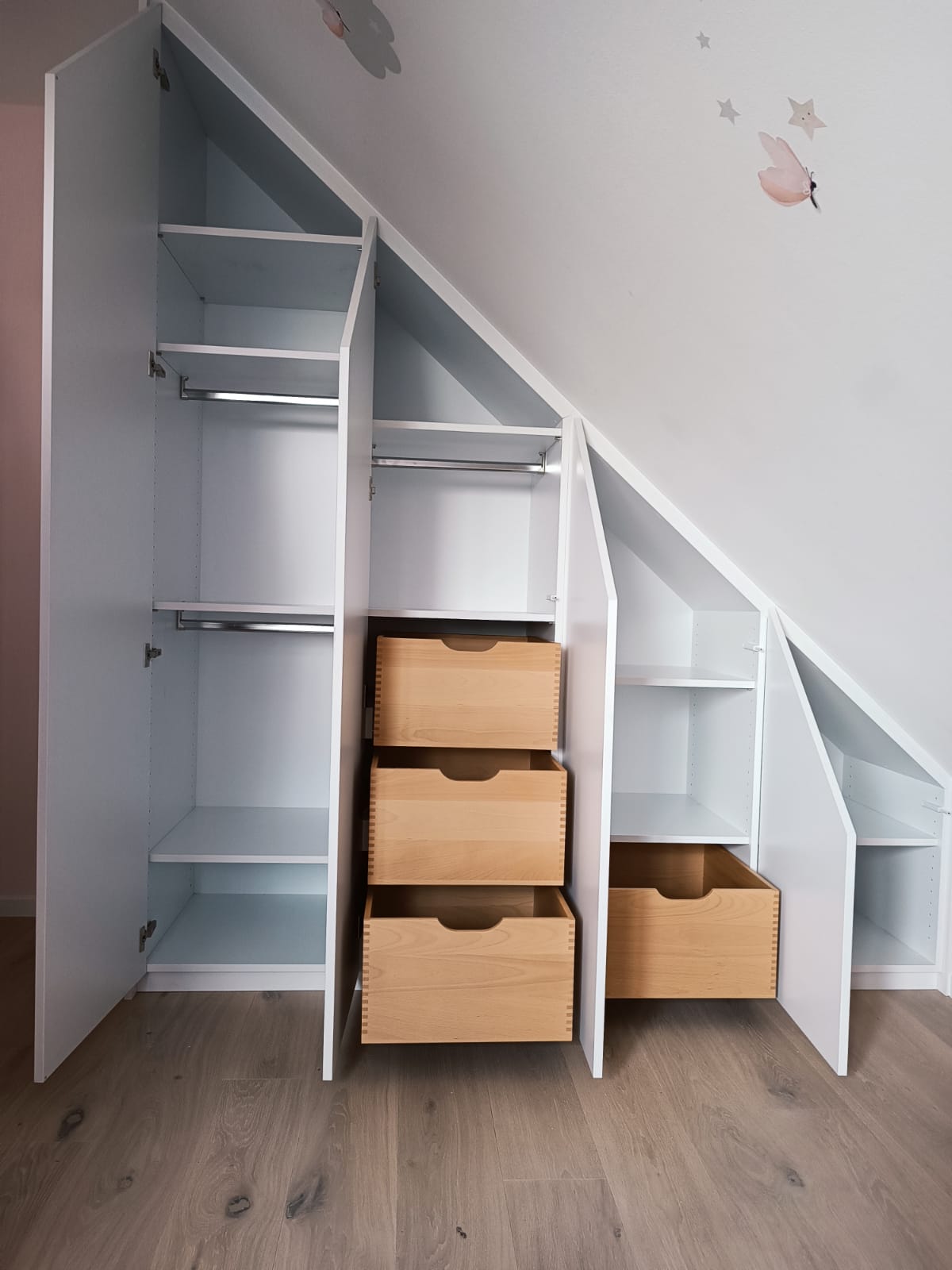 Einbauschrank in einem Kinderzimmer mit Dachschräge - geöffnete Ansicht