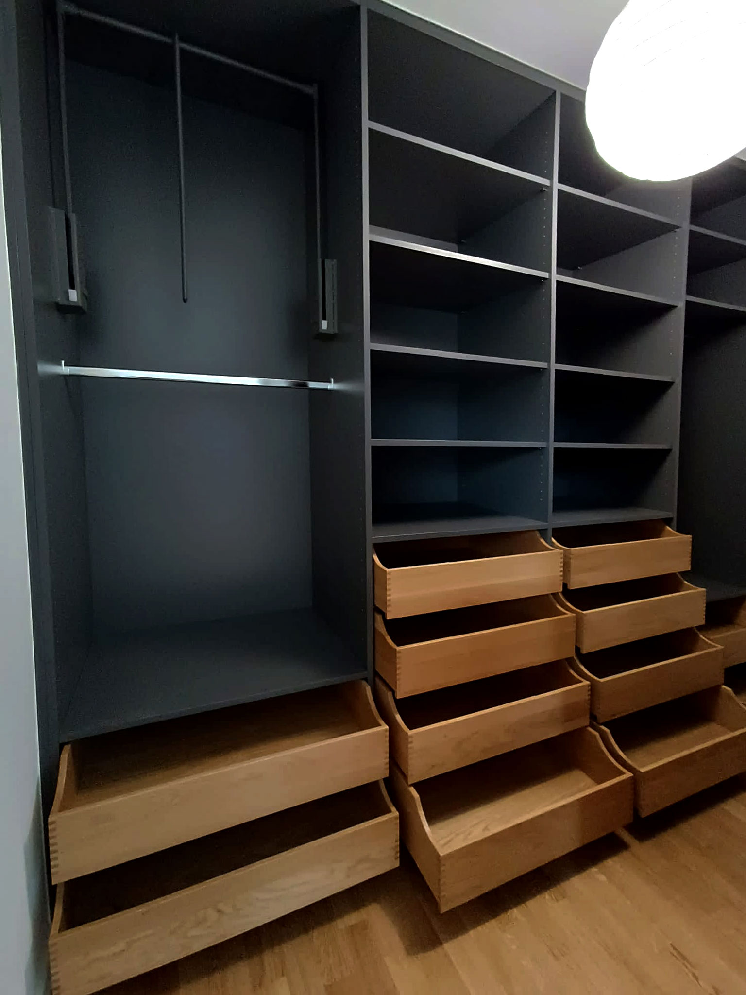 Gaphitgrauer Einbauschrank mit Garderobenlifter und hölzernen Schubladen aus Echtholz in einem begehbaren Kleiderschrank