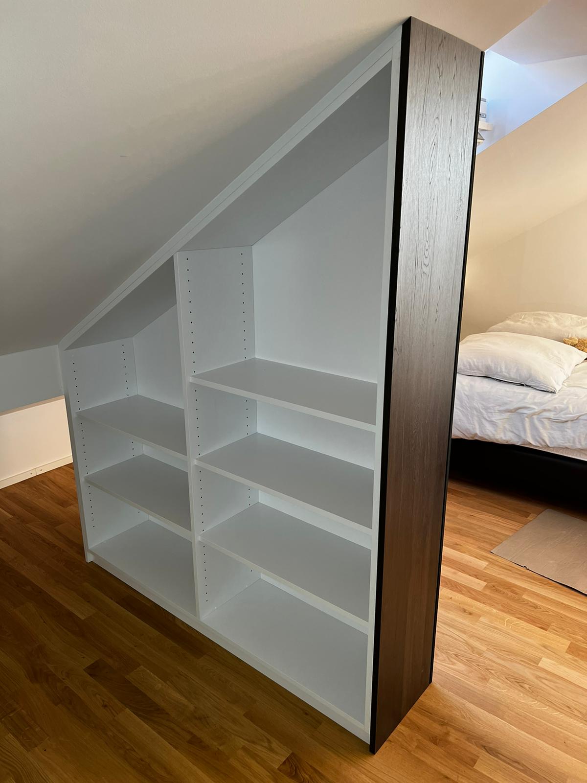 Der schräge Raumteiler trennt das Schlafzimmer vom begehbaren Kleiderschrank